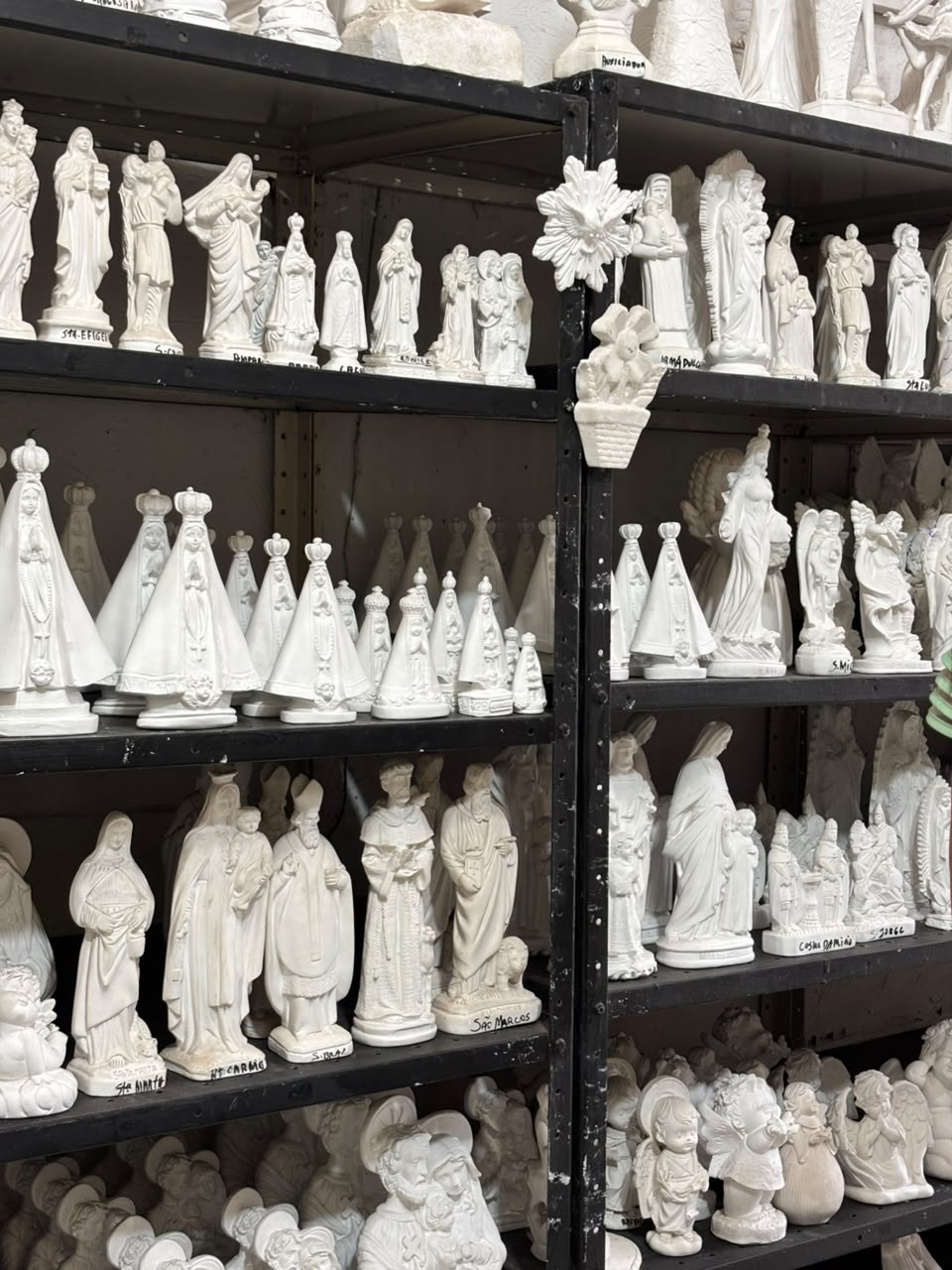 Prateleiras da oficina com peças de gesso em branco prontas para pintura